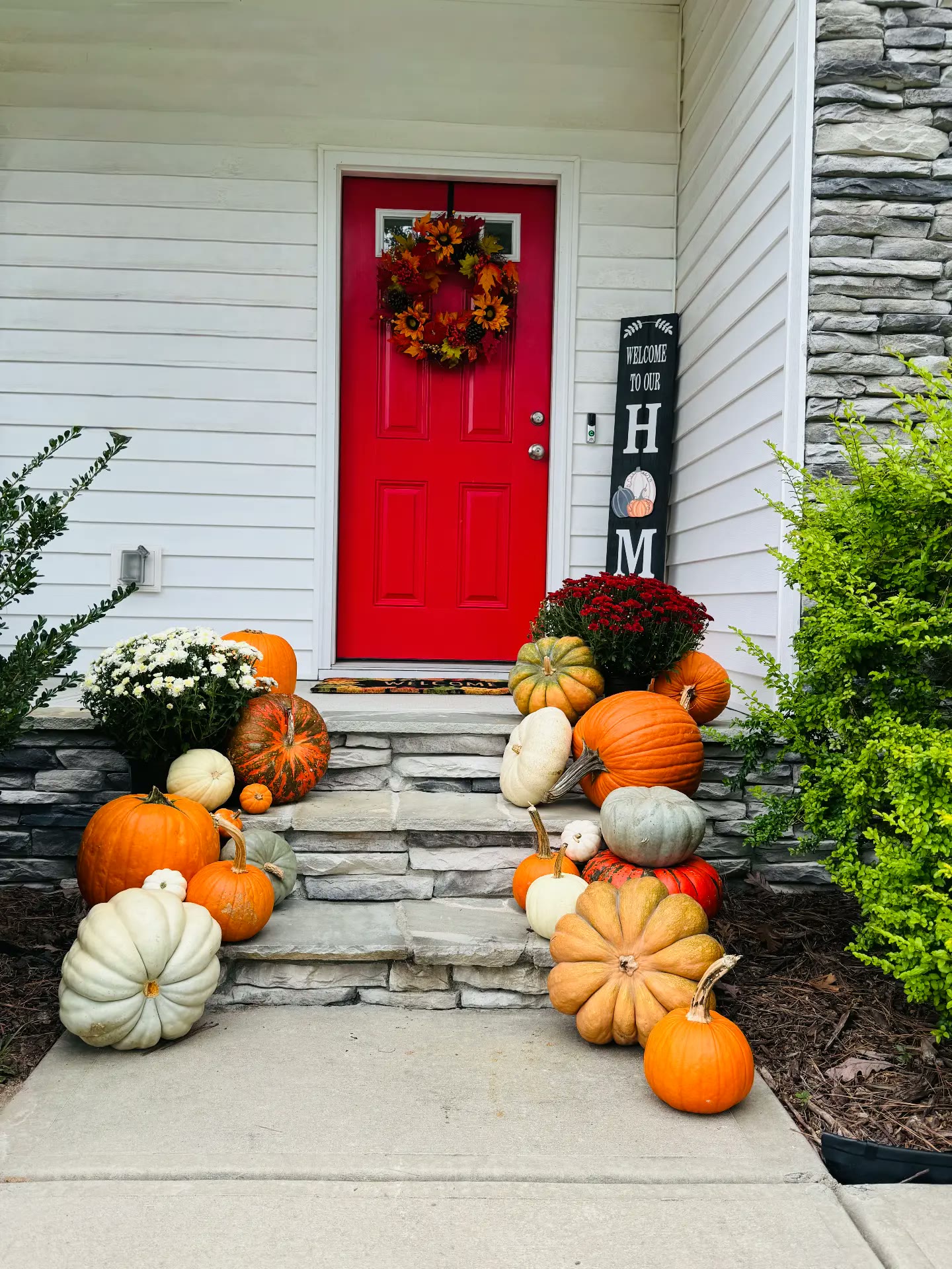 Red front door porch styled with pumpkins, gourds and mums in Knightdale, NC
